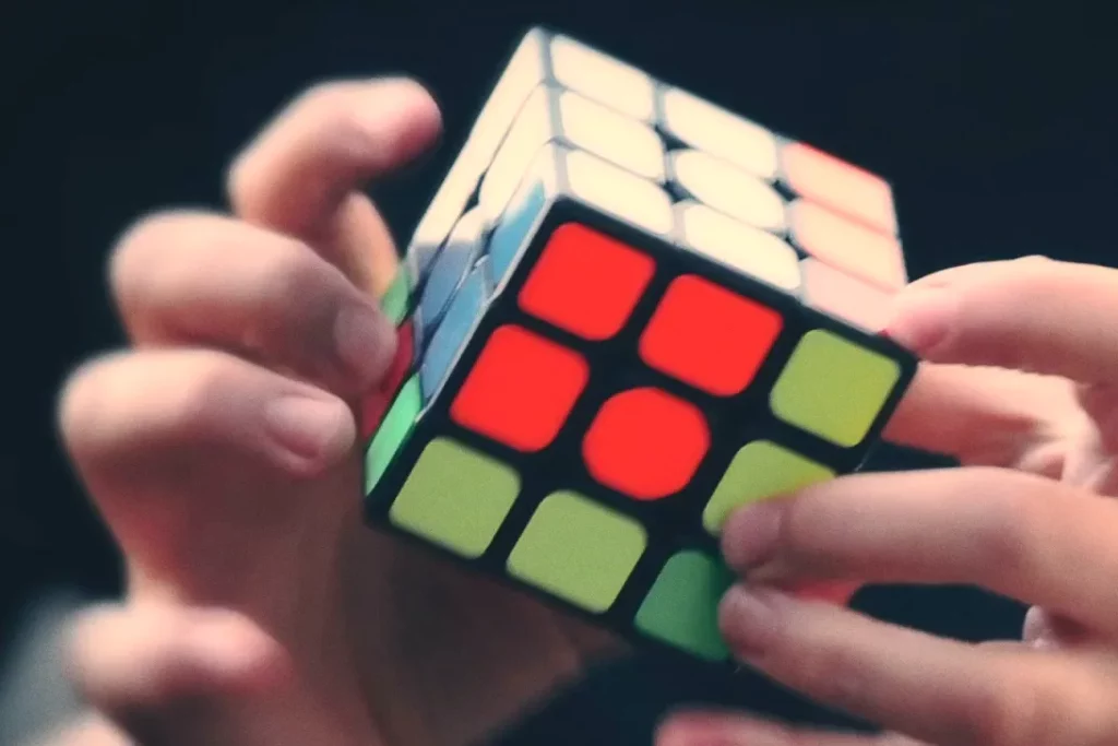 Unas manos giran un cubo de Rubik, imagen del vídeo de la edición «Las caras de la lectura» de El Placer de Leer